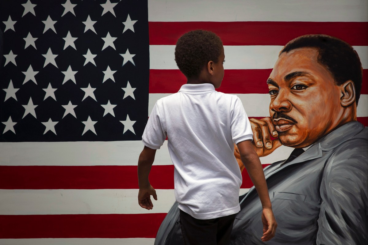 A young child walks past a painting depicting Dr. Martin Luther King Jr. during a Juneteenth celebration in Los Angeles on June 19, 2020. Juneteenth marks the day in 1865 when federal troops arrived in Galveston, Texas, to take control of the state and ensure all enslaved people were freed, more than two years after the Emancipation Proclamation. AP Photo/Jae C. Hong