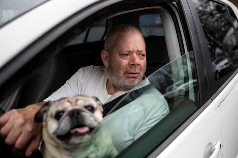 Ira Porter and his dog Biggee wait in line to receive food at the Trinity County Food Bank distribution at the Trinity County Fairgrounds on Feb. 8, 2023. Photo by Martin do Nascimento, CalMatters