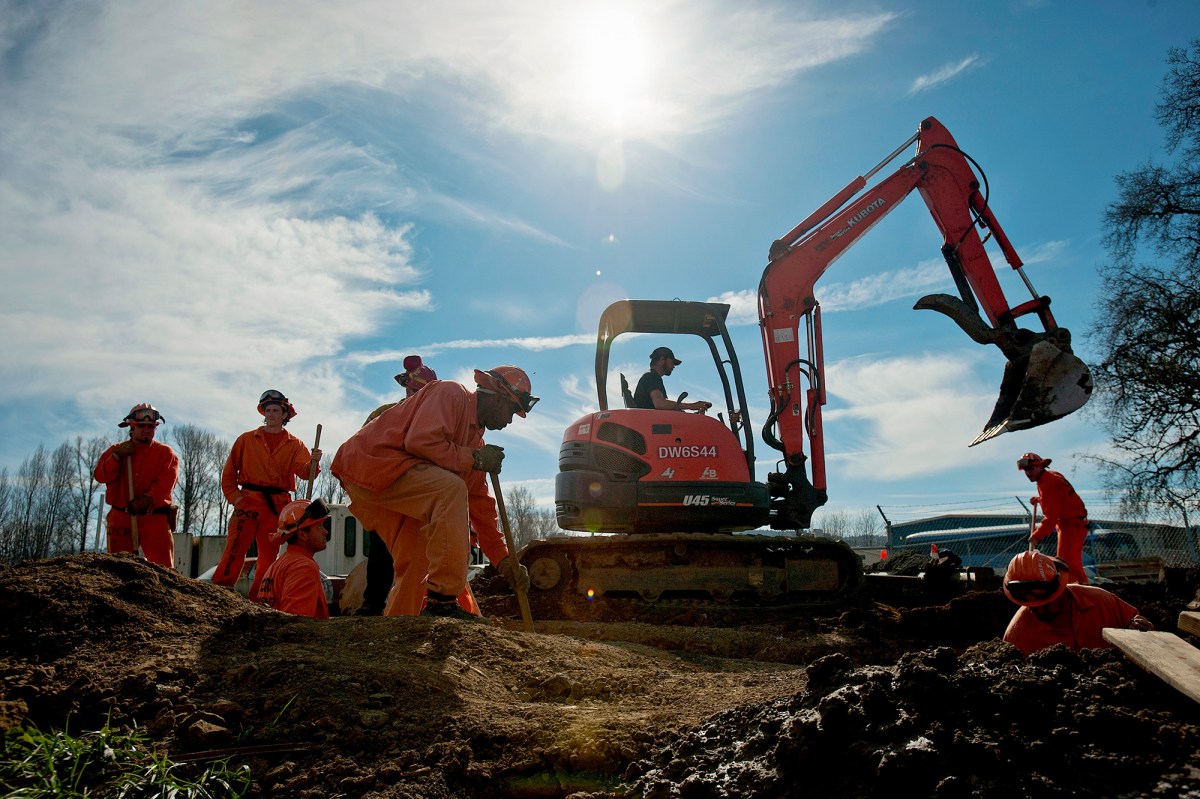 California prison laborers and an excavator operator help construct an emergency pipeline to increase supplies of potable water in Willits in 2014. REUTERS/Noah Berger