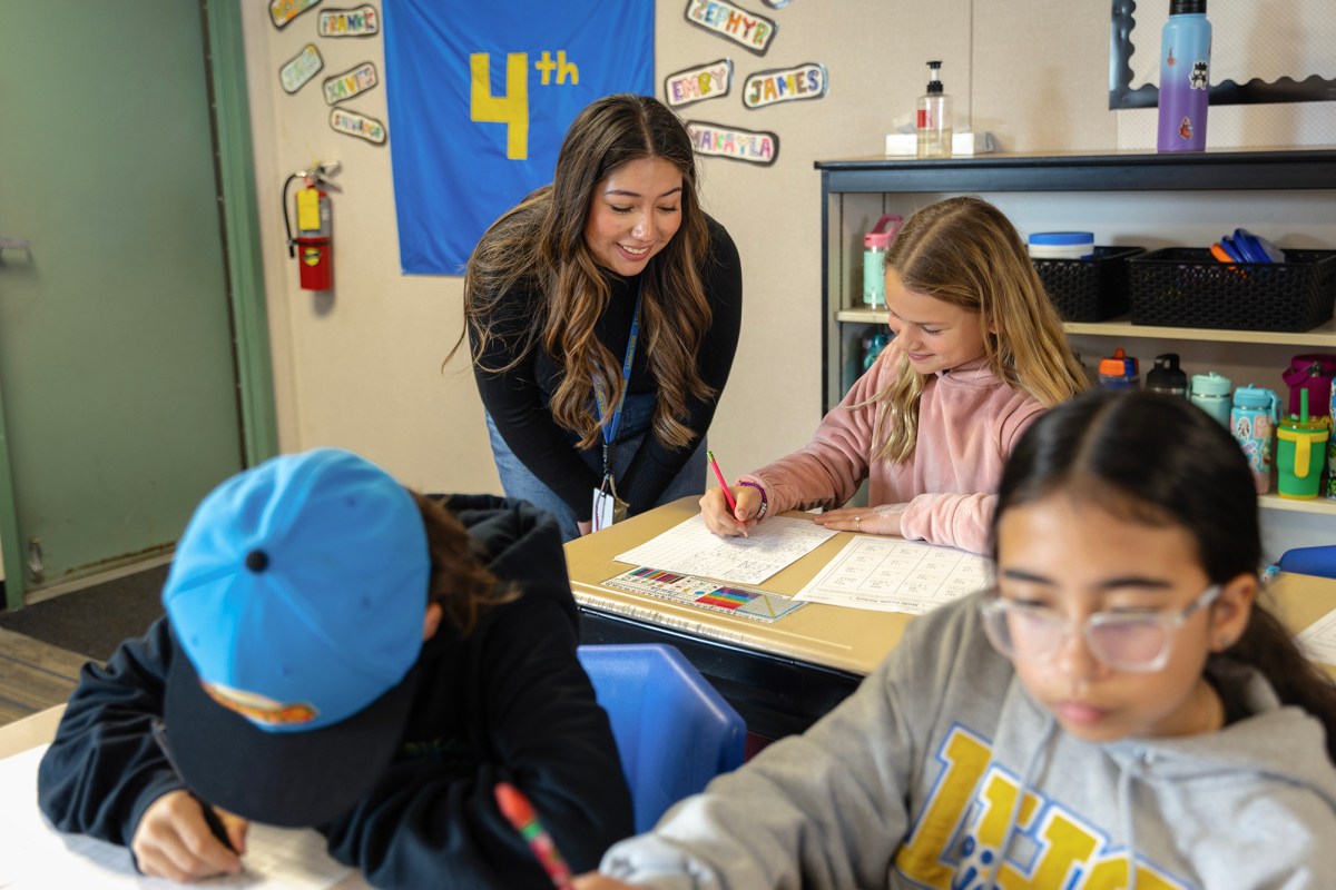 High school senior Catalina Govea, 17, helps a fourth-grade student at Linden Elementary School in San Joaquin County as part of a youth apprenticeship program on March 5, 2024. Photo by Manuel Orbegozo for CalMatters