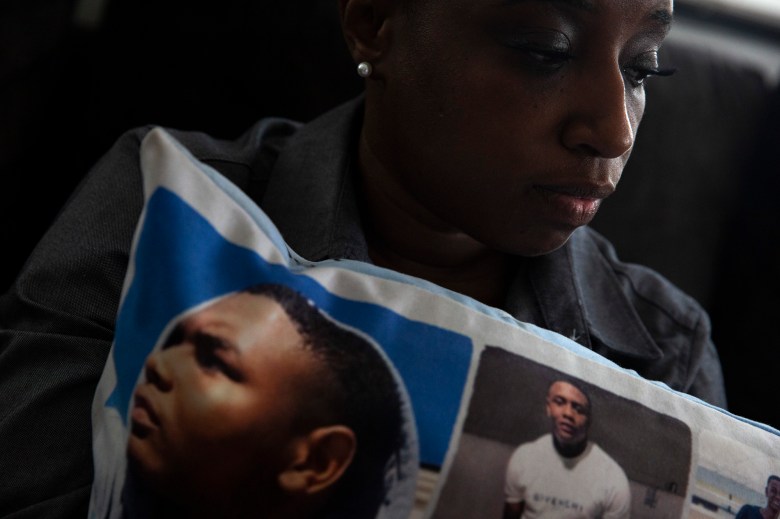 Jennifer Maraston holds a pillow covered in photos of her son Jaquan Wyatt, who was murdered the day after he turned 21 while traveling in California. It has been nearly two years since his homicide, but court proceedings have been delayed by challenges involving COVID-19 and the amount of people charged in the case. Photo by Shelby Tauber for CalMatters