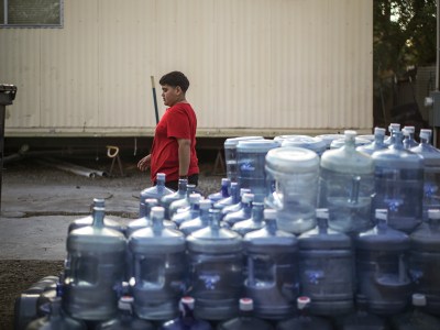 A stack of empty five-gallon water containers at Shady Lane Estates in Thermal on March 23, 2023. According to some residents, there is no clean drinking water from the mobile park, so these five-gallon containers are their only option. Pablo Unzueta for CalMatter