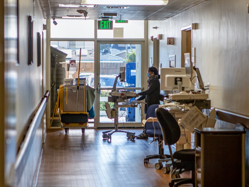 A medical personnel working on her computer in the corridor of Hazel Hawkins Memorial Hospital in Hollister on March 30, 2023. Photo by Larry Valenzuela, CalMatters/CatchLight Local