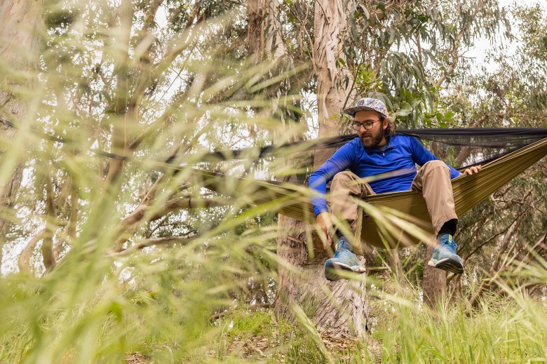 Kenneth Bevens, a Cal Poly student majoring in recreation parks and tourism administration, sets up a hammock at Montana De Oro State Park in San Luis Obispo County on April 23, 2024. Photo by Julie Leopo-Bermudez for CalMatters