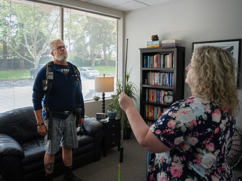 Todd Nelson and Jennifer Alexander conduct a brainspotting exercise that involves Nelsen wearing firefighting equipment at Alexander's office in Gold River on April 24, 2024. Photo by Cristian Gonzalez for CalMatters