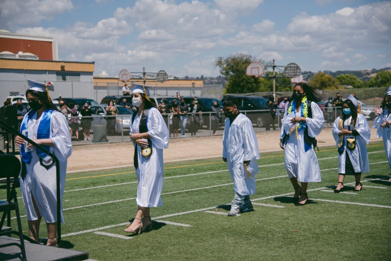 Graduates line up to receive their diplomas during a commencement ceremony at Madison Park Academy in Oakland on May 21, 2021. Photo by Marissa Leshnov for CalMatters