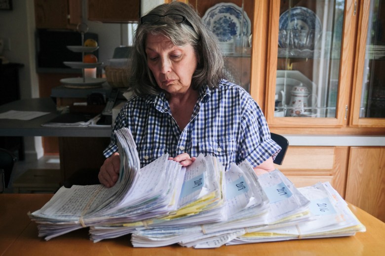 Susan Ottele looking through stacks of handwritten letters that her son Adam Joseph Collier mailed to her between 2016 - 2020 while being held in the California State prison system. Photo by Tojo Andrianarivo for CalMatters