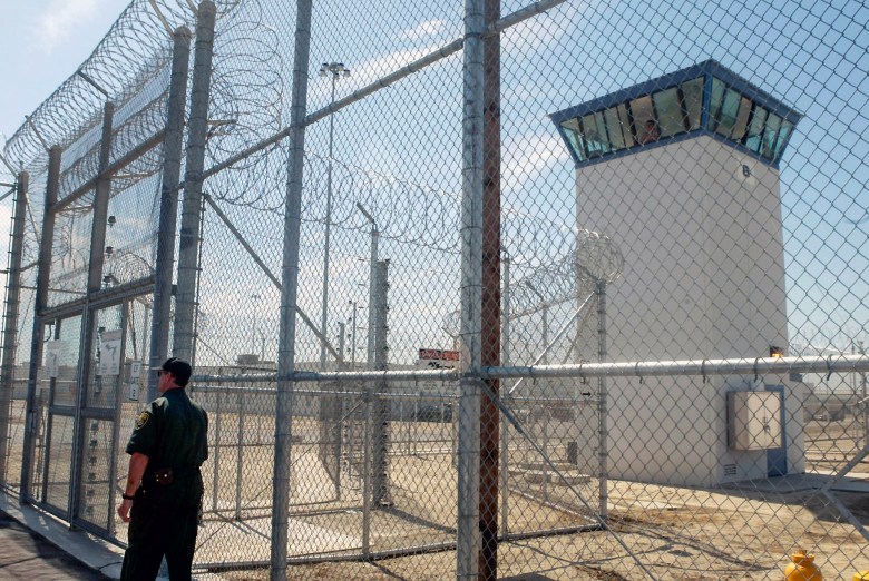 A correctional officer walks near one of two entrances into Kern Valley State Prison, in Delano on June 14, 2005. Photo by Ric Francis, AP Photo