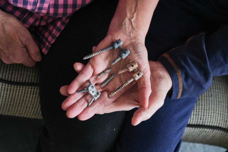 Susan Ottele and her husband Will holding the screws removed from their son Adam Joseph Collier’s back. Collier committed suicide while in solitary confinement in a California state prison. Photo by Tojo Andrianarivo for CalMatters