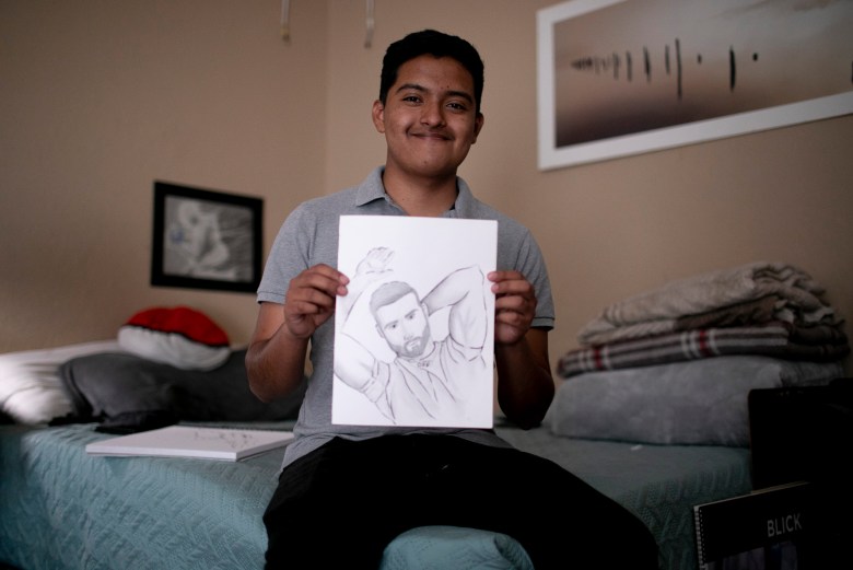 Eduardo holds up a recent drawing. He hopes to continue learning illustration at Cal State East Bay. Photo by Anne Wernikoff, CalMatters