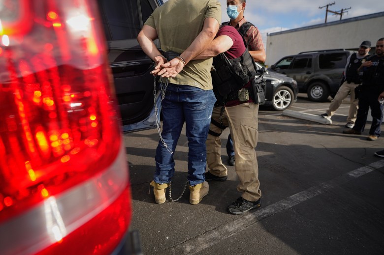 U.S. Immigration and Customs Enforcement agents transfer an immigrant after an early morning raid in Duarte on June 6, 2022. Photo by Damian Dovarganes, AP Photo