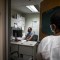 STD Investigator Hou Vang (left) works in his office as Jena Adams (right), Communicable Disease Program Manager, checks in on him on June 8, 2022. Photo by Larry Valenzuela, CalMatters/CatchLight Local