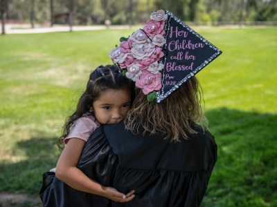 Yessenia Cervantes, 34, holds her youngest daughter, Issabella Cervantes, at California Citrus State Historic Park in Riverside on June 17, 2022. “I can’t forget that I’m a mom before anything else,” Cervantes, who recently graduated with an associate’s degree from Riverside City College, said. “I know that I’m working towards something bigger—for my children’s future.” Photo by Pablo Unzueta for CalMatters