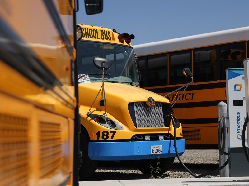 An electric school bus is charging at Grant Union High School in Sacramento on July 20, 2023. The chargers are bidirectional, which means they can feed power back to the electric grid. Photo by Miguel Gutierrez Jr., CalMatters