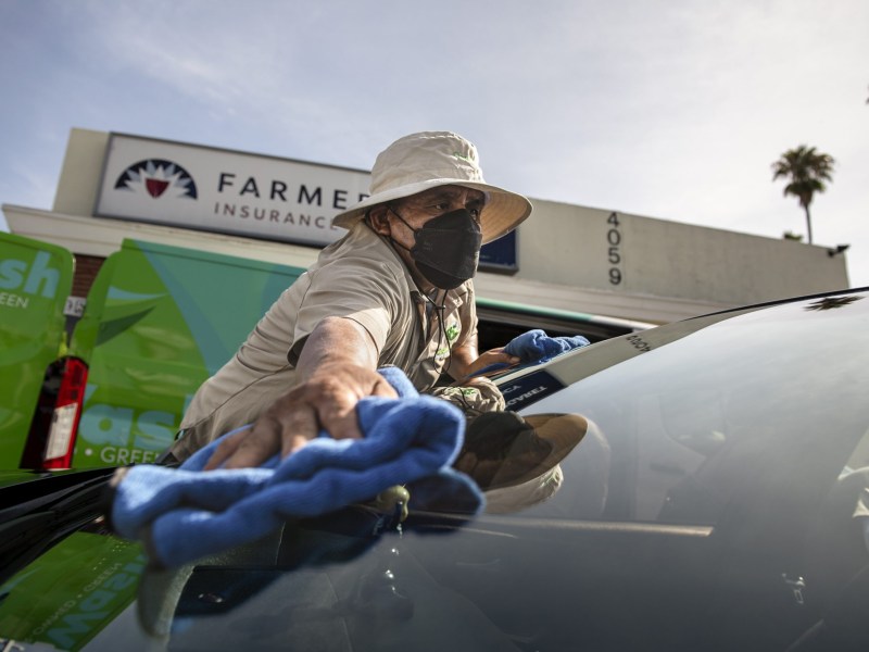 Rodrigo Hernandez, 50, finishes up a car after washing it outside of the CLEAN Carwash Worker Center, in Los Angeles on July 21, 2022. Photo by Pablo Unzueta for CalMatters