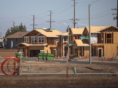 The wooden frames of houses under construction are visible on a residential street in Goshen.