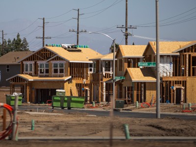 The wooden frames of houses under construction are visible on a residential street in Goshen.