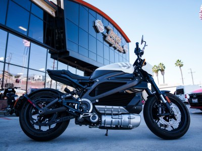 An electric motorcycle parked in front of a motorcycle dealership.