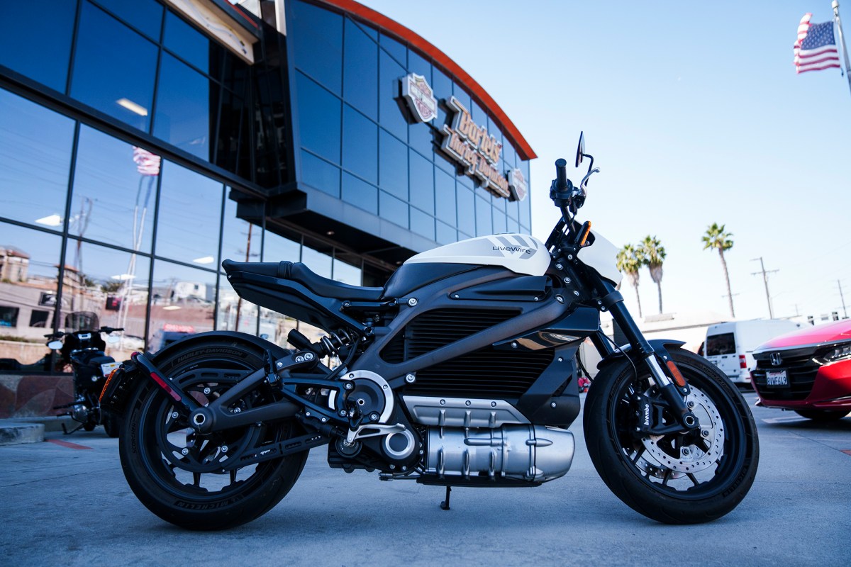 An electric motorcycle parked in front of a motorcycle dealership.