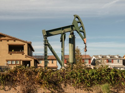 An active oil derrick near homes in the city of Signal Hill in Los Angeles County on Oct. 19, 2022. Photo by Pablo Unzueta for CalMatters