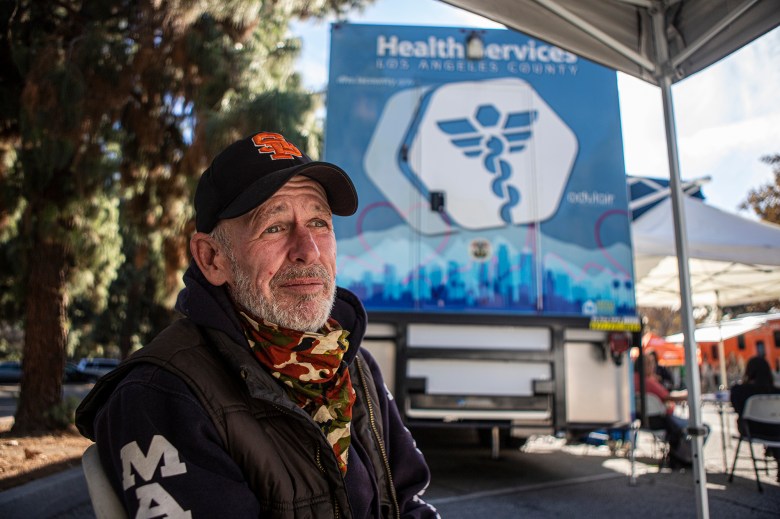 Unhoused patient Danny Doran sits in the waiting area for the mobile clinic parked in Whittier Narrows Park on Nov. 17, 2022. Doran is being checked up after being assaulted near his encampment just a few days before. Photo by Larry Valenzuela for CalMatters