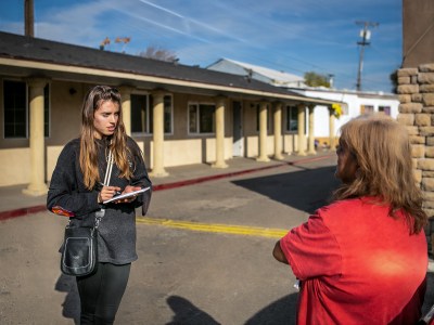 CalMatters housing reporter Manuela Tobias (left) interviews Marina Salinas at her residency at the Stockton City Hotel in Stockton on Nov. 22, 2022. Photo by Rahul Lal, CalMatters