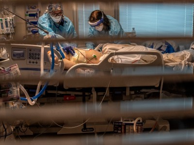 Phlebotomist lab assistant Jennifer Cukati, right, and Registered Nurse Carina Klescewski, left, care for a COVID-19 patient inside the Sutter Roseville Medical Center ICU in Roseville on Dec. 22, 2020. California became the first state to record 2 million confirmed coronavirus cases, reaching the milestone on Christmas Eve as close to the entire state was under a strict stay-at-home order and hospitals were flooded with the largest crush of cases since the pandemic began. Photo by Renee C. Byer, The Sacramento Bee via AP/Pool